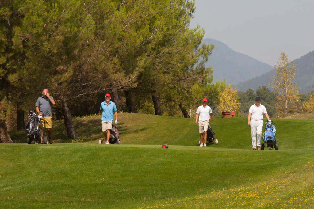 Golfistas caminan entre dos hoyos